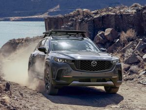 Mazda CX-50 driving on dirt road.