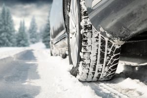 Car driving in snow, closeup on snow covered tires.