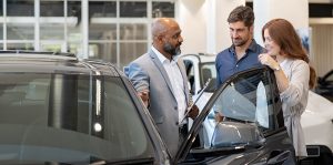 Sales associate showing customers a vehicle