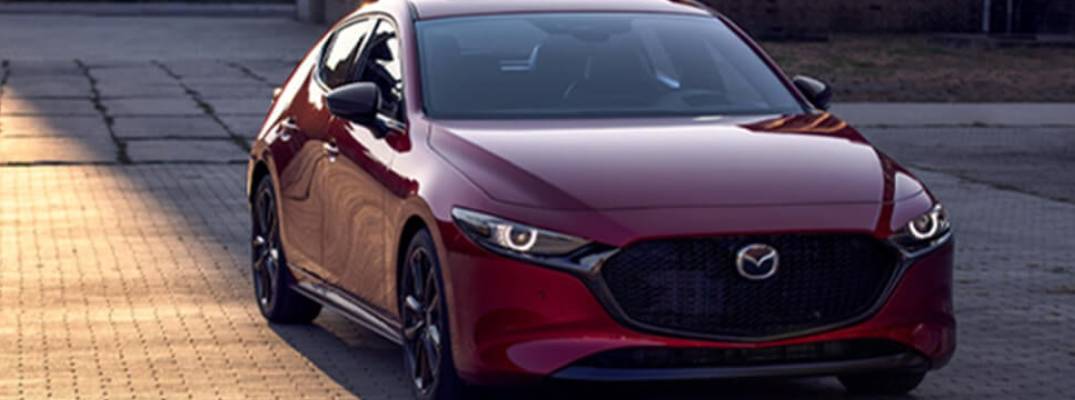 Mazda parked on pavement. 